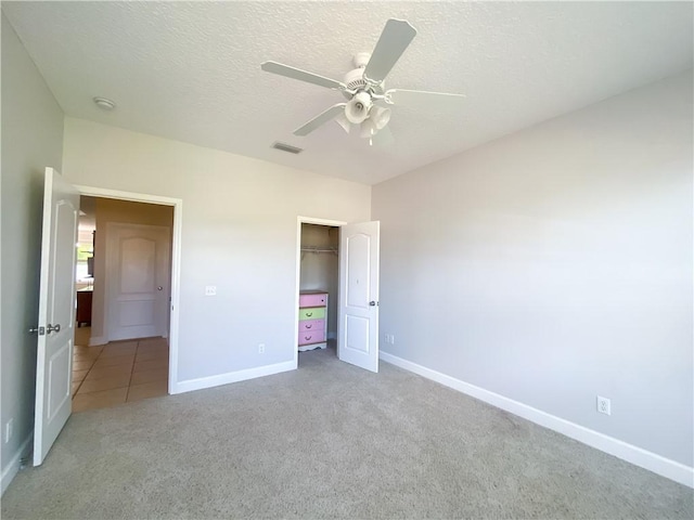 unfurnished bedroom with carpet floors, visible vents, a closet, baseboards, and ceiling fan