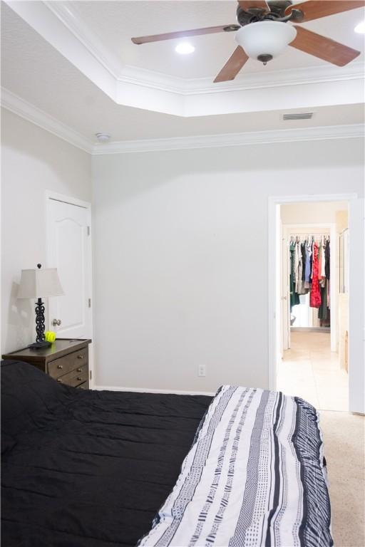 bedroom featuring recessed lighting, a tray ceiling, ornamental molding, and ceiling fan