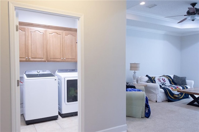 laundry room featuring crown molding, a ceiling fan, cabinet space, independent washer and dryer, and light tile patterned floors