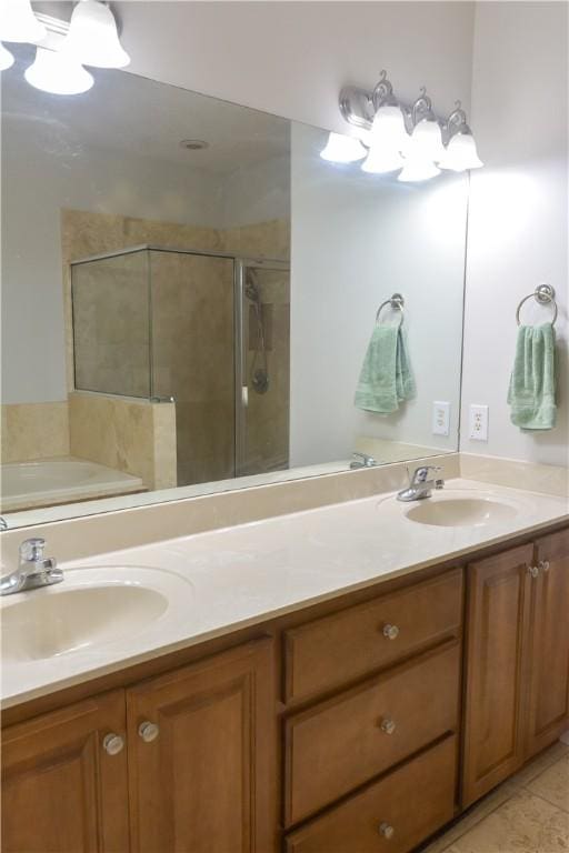 full bath with a sink, a shower stall, and double vanity