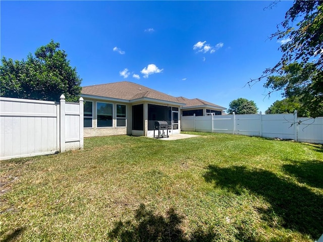 rear view of property with a sunroom, a fenced backyard, and a lawn