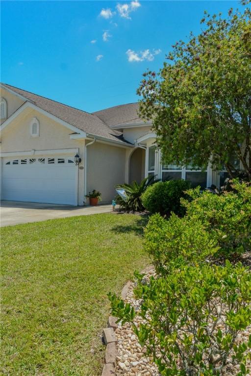 view of front of home featuring stucco siding, an attached garage, driveway, and a front lawn