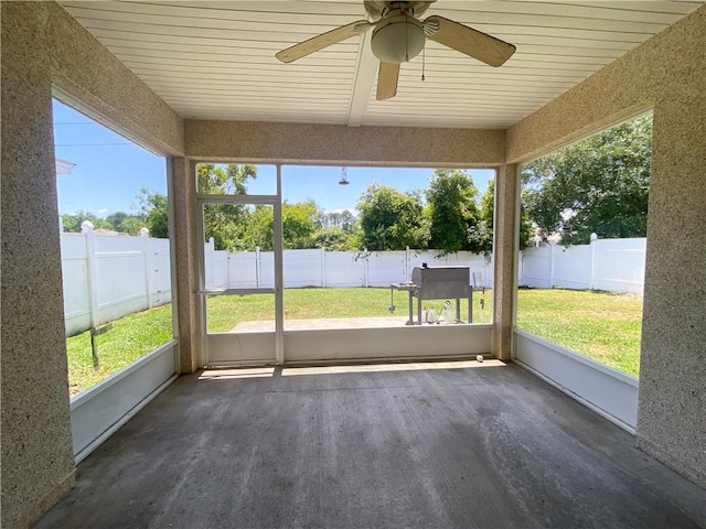 unfurnished sunroom with a ceiling fan and a healthy amount of sunlight