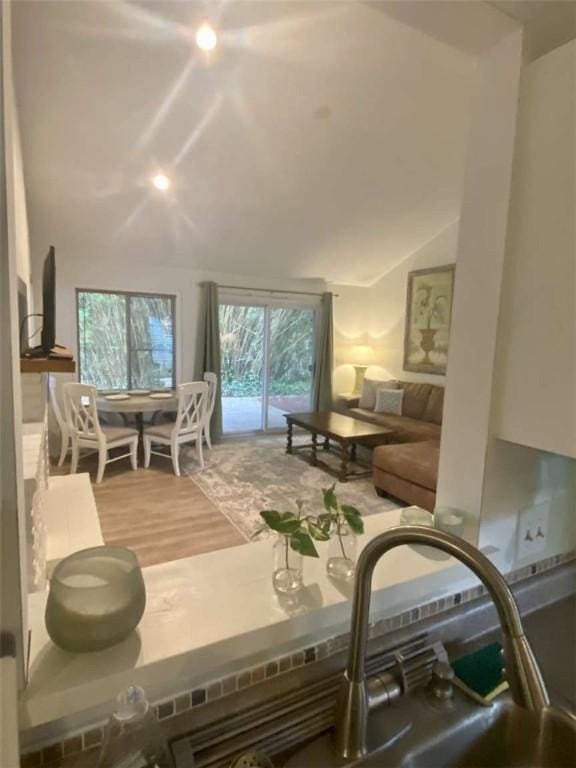 living room with lofted ceiling and wood finished floors