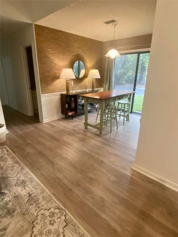 dining area with baseboards, visible vents, and wood finished floors