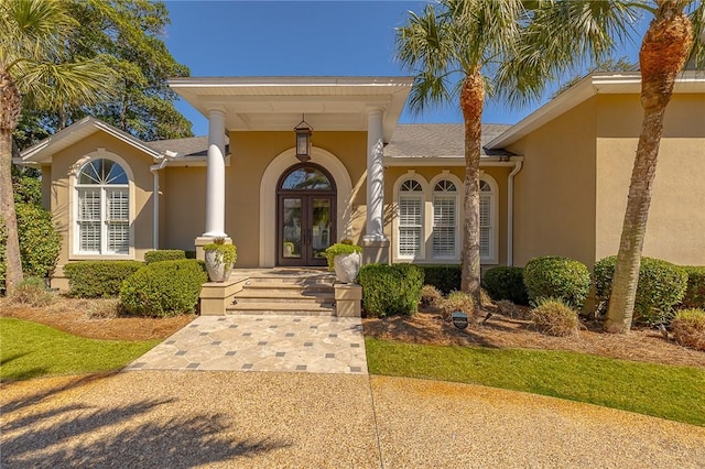 doorway to property featuring french doors and stucco siding