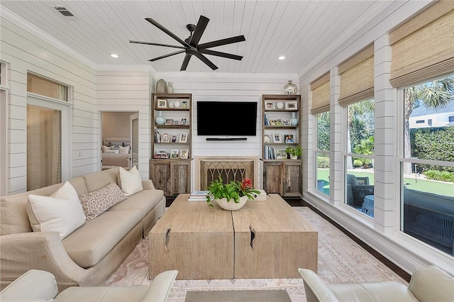 living room featuring wood walls, wood ceiling, a fireplace, and visible vents