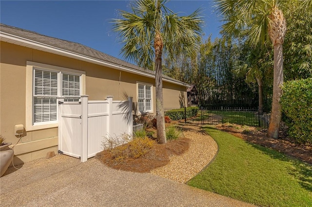 view of side of property featuring fence and stucco siding