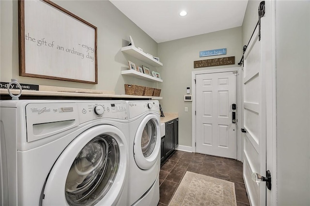 washroom featuring cabinet space, a barn door, baseboards, and separate washer and dryer