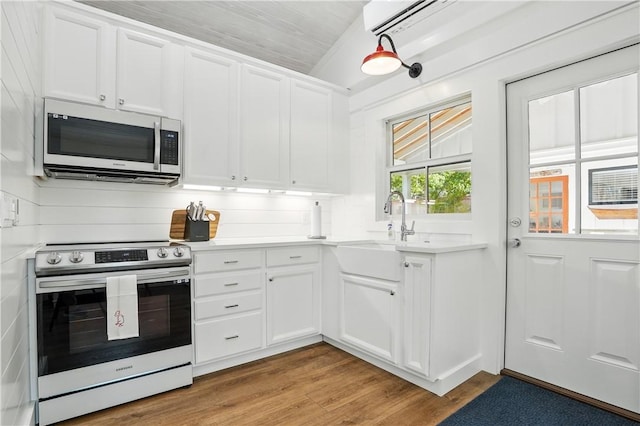 kitchen with white cabinetry, stainless steel appliances, light countertops, and a sink