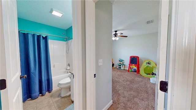 bathroom with tile patterned floors, visible vents, a textured ceiling, shower / bath combination with curtain, and ceiling fan