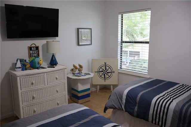 bedroom with light wood-type flooring and multiple windows