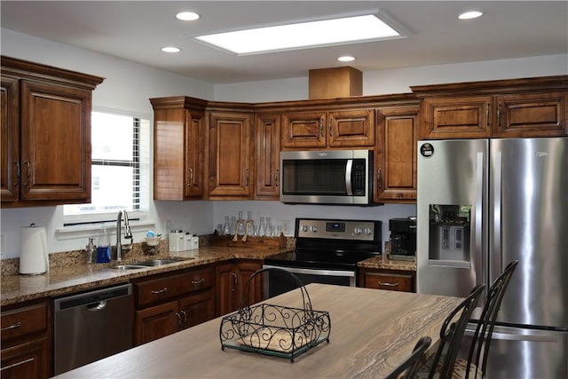 kitchen with dark stone countertops, sink, and appliances with stainless steel finishes