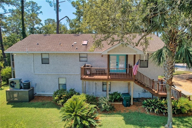 rear view of property featuring a wooden deck, a yard, and ac unit