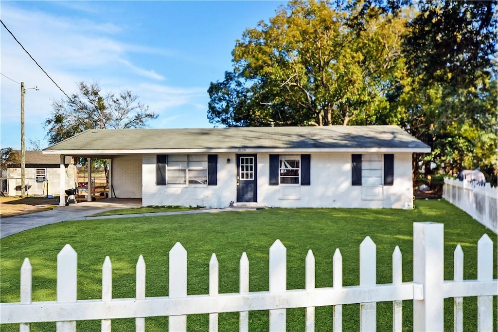 ranch-style home with a carport and a front lawn