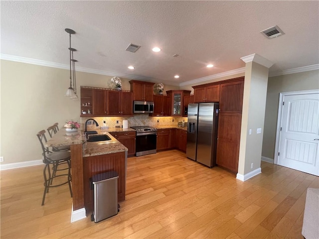 125 Palmera Ln, Brunswick, GA 31525 - kitchen with stainless steel appliances, a sink, a peninsula, a kitchen bar, and glass insert cabinets
