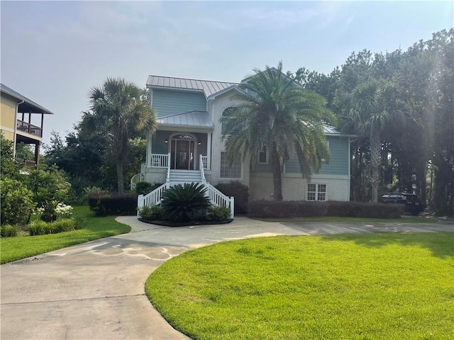 125 Palmera Ln, Brunswick, GA 31525 - view of front of home featuring stairway, a front yard, a standing seam roof, stucco siding, and metal roof
