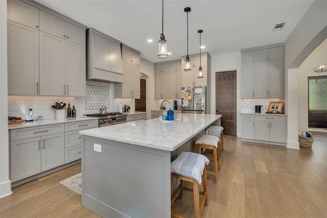 147 Butler Lake Dr, Saint Simons Island, GA 31522 - kitchen featuring stainless steel appliances, custom exhaust hood, tasteful backsplash, recessed lighting, and light wood-type flooring