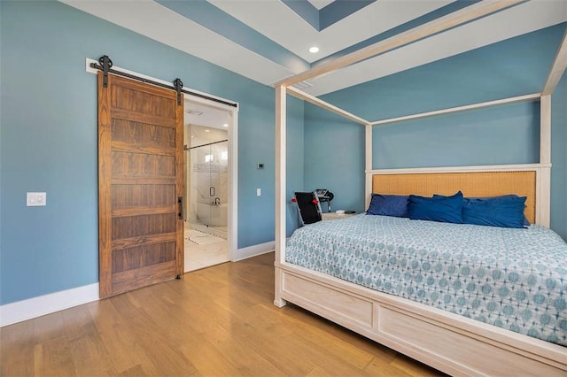 147 Butler Lake Dr, Saint Simons Island, GA 31522 - bedroom featuring wood finished floors, a barn door, recessed lighting, and connected bathroom