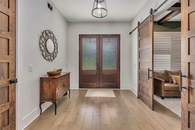 147 Butler Lake Dr, Saint Simons Island, GA 31522 - entrance foyer with a barn door, french doors, and light wood finished floors
