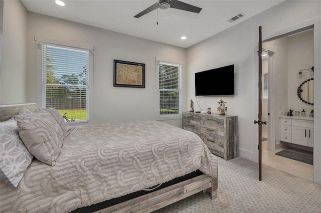 147 Butler Lake Dr, Saint Simons Island, GA 31522 - bedroom featuring multiple windows, recessed lighting, connected bathroom, light colored carpet, and ceiling fan