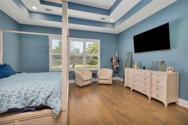 147 Butler Lake Dr, Saint Simons Island, GA 31522 - bedroom with wood finished floors, a raised ceiling, and recessed lighting