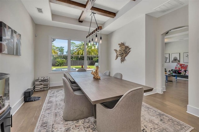 147 Butler Lake Dr, Saint Simons Island, GA 31522 - dining room with coffered ceiling, arched walkways, wood finished floors, and beamed ceiling