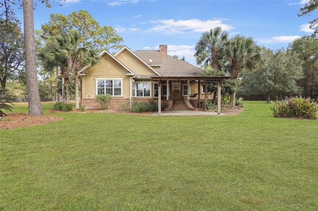 rear view of property featuring a lawn