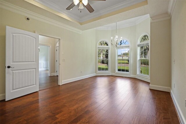 spare room featuring dark hardwood / wood-style flooring, ceiling fan with notable chandelier, and ornamental molding