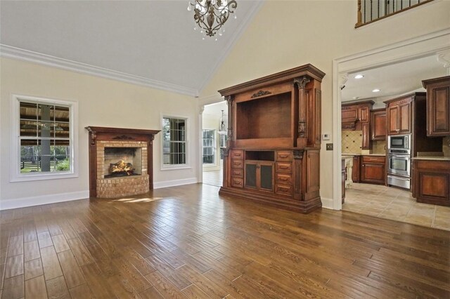 unfurnished living room featuring hardwood / wood-style flooring, plenty of natural light, and ornamental molding