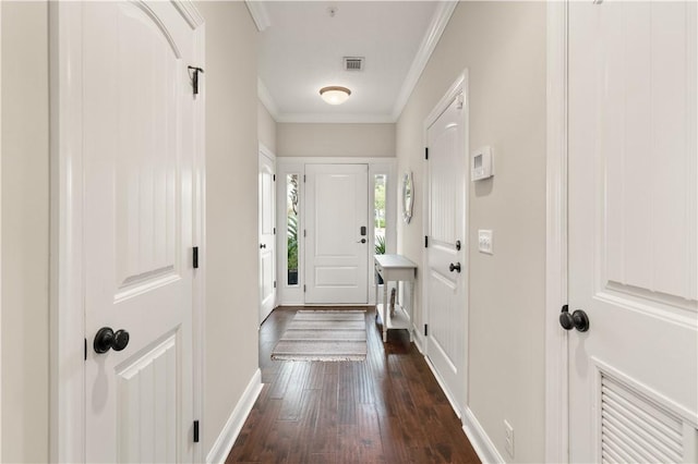 entryway with ornamental molding, dark wood-style flooring, visible vents, and baseboards