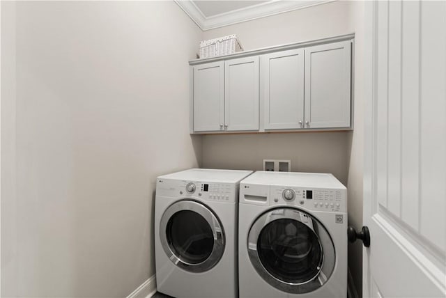 washroom featuring washer and dryer, cabinet space, crown molding, and baseboards