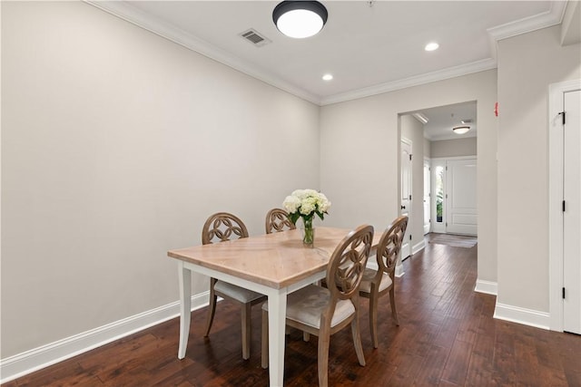 dining room with crown molding, dark wood-type flooring, visible vents, and baseboards