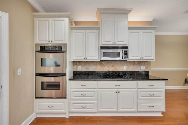 253 Winding Trl, Brunswick, GA 31523 - kitchen with appliances with stainless steel finishes, crown molding, decorative backsplash, dark stone countertops, and light wood-style floors