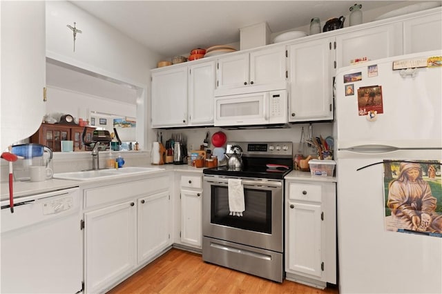 kitchen with white cabinets, white appliances, light hardwood / wood-style floors, and sink