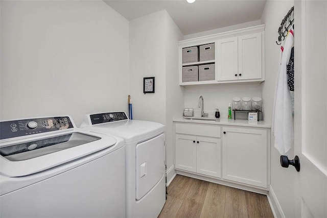 121 Fifty Oaks Ln, Saint Simons Island, GA 31522 - laundry area with independent washer and dryer, light wood-style floors, cabinet space, and baseboards