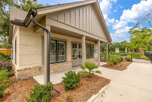 121 Fifty Oaks Ln, Saint Simons Island, GA 31522 - doorway to property with board and batten siding, brick siding, and a patio area