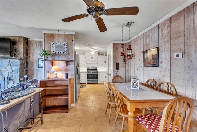 dining area featuring wood walls and light tile patterned flooring