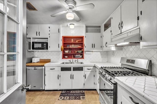 kitchen featuring sink, white cabinets, stainless steel appliances, and light tile patterned floors