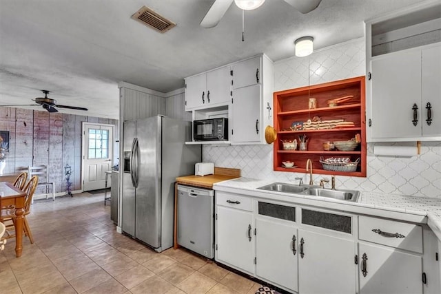 kitchen with white cabinets, backsplash, sink, and stainless steel appliances