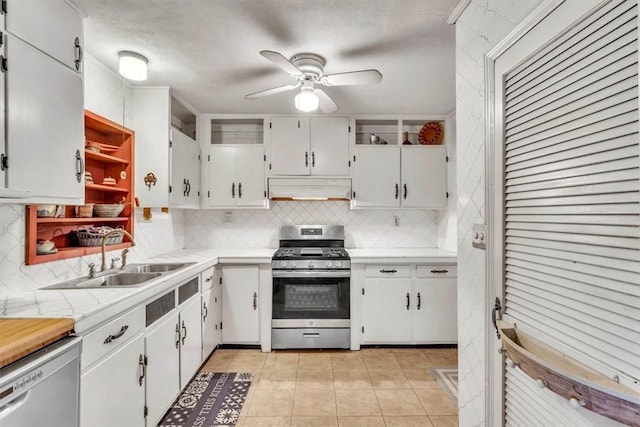 kitchen featuring tasteful backsplash, stainless steel appliances, sink, light tile patterned floors, and white cabinets