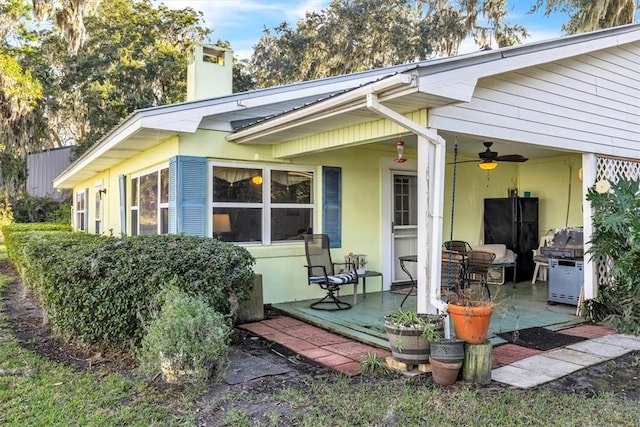 back of property featuring ceiling fan and a patio area