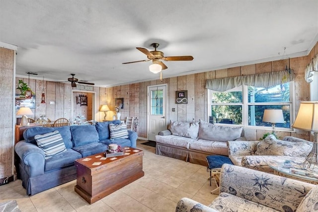 tiled living room with ceiling fan and wood walls