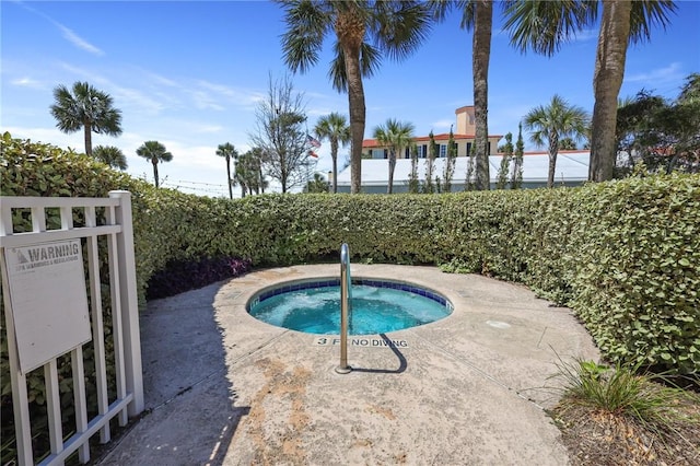 view of pool with a hot tub and fence