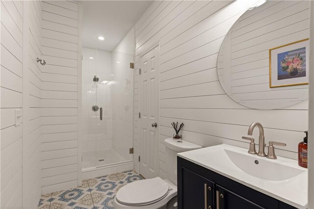 bathroom with tile patterned floors, an enclosed shower, vanity, toilet, and wood walls