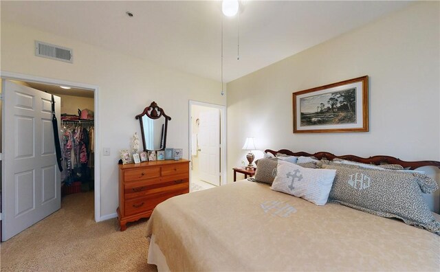 carpeted bedroom with a spacious closet, ensuite bath, and a closet