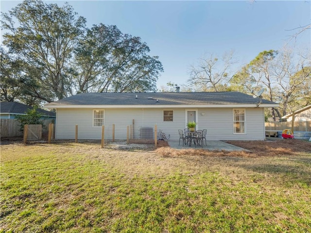 back of house with a patio area and a lawn