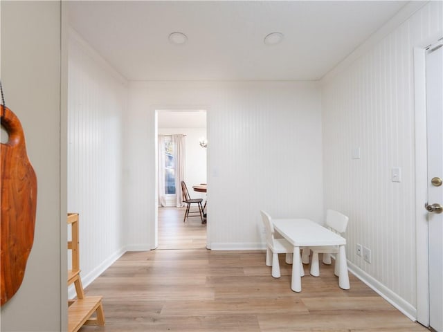 dining space with crown molding and light hardwood / wood-style flooring