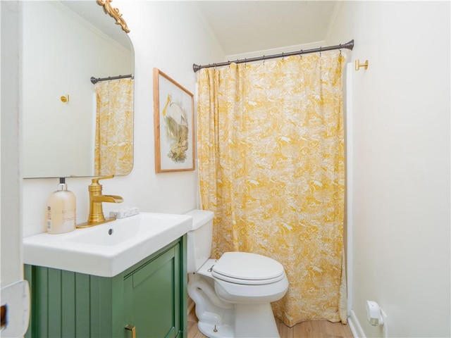 bathroom with vanity, crown molding, and toilet