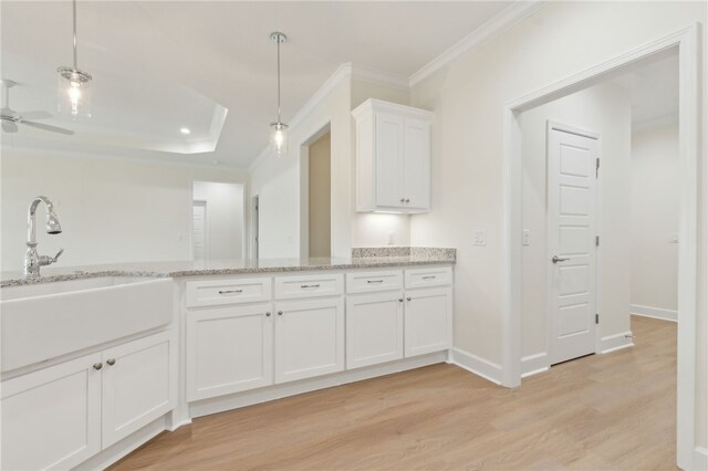 177 Verano St, Kingsland, GA 31548 - kitchen with ornamental molding, white cabinetry, light wood-type flooring, light stone countertops, and hanging light fixtures